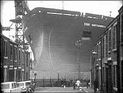 A huge ship bloacks the end of a narrow street, giving the gifted just one way to go.