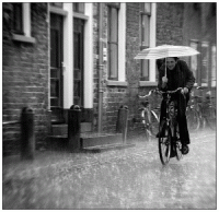 A man rides through the rain in a British street