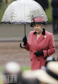 Queen Elizabeth II holds a transparent umbrella