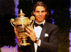 Rafael Nadal in a tuxedo holds up his Wimbledon Championship cup