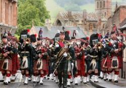 A marching band of scottish soldiers in kilts